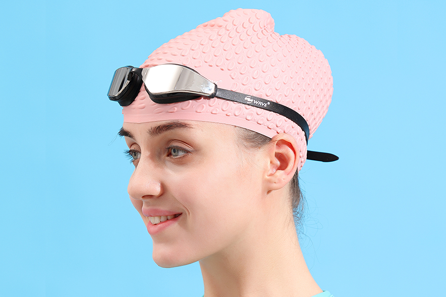 a woman wearing the swimming goggle and cap