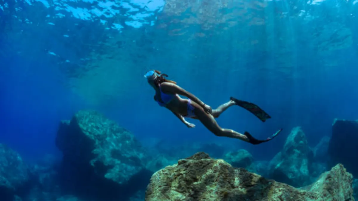 a girl dives in apnea in the crystal clear waters of the Mediterranean