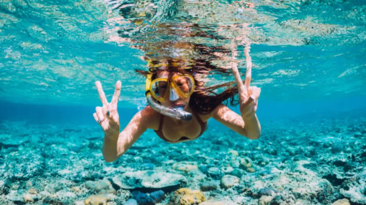a girl is diving under the sea