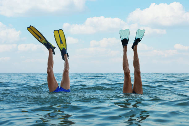 Men in flippers diving into sea