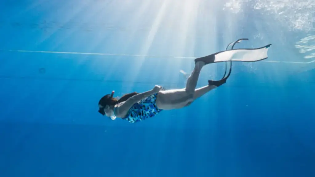 Young Woman Scuba Dives on a Coral Reef