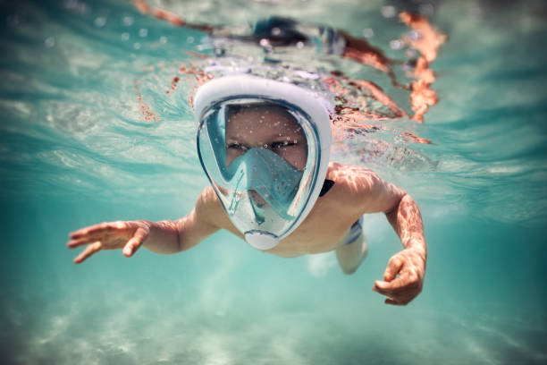 Little boy snorkeling in modern full face snorkel mask