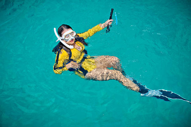 Woman tourist in seawater in moment practice free diving
